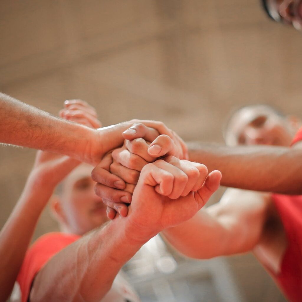 basketball team stacking hands together