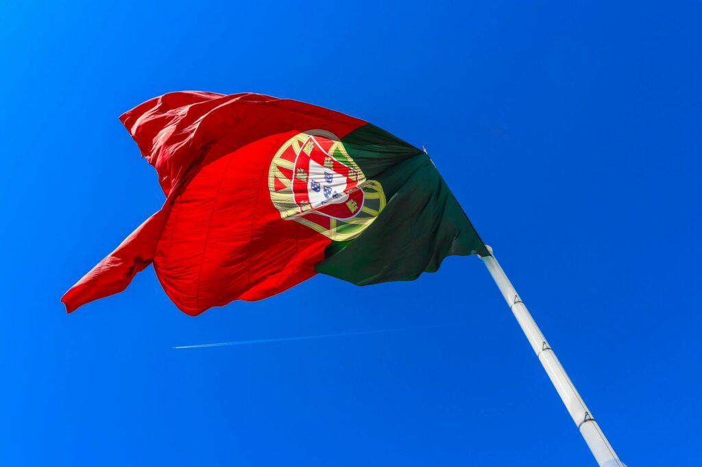 low angle shot of the portuguese flag on the background of a clear blue sky